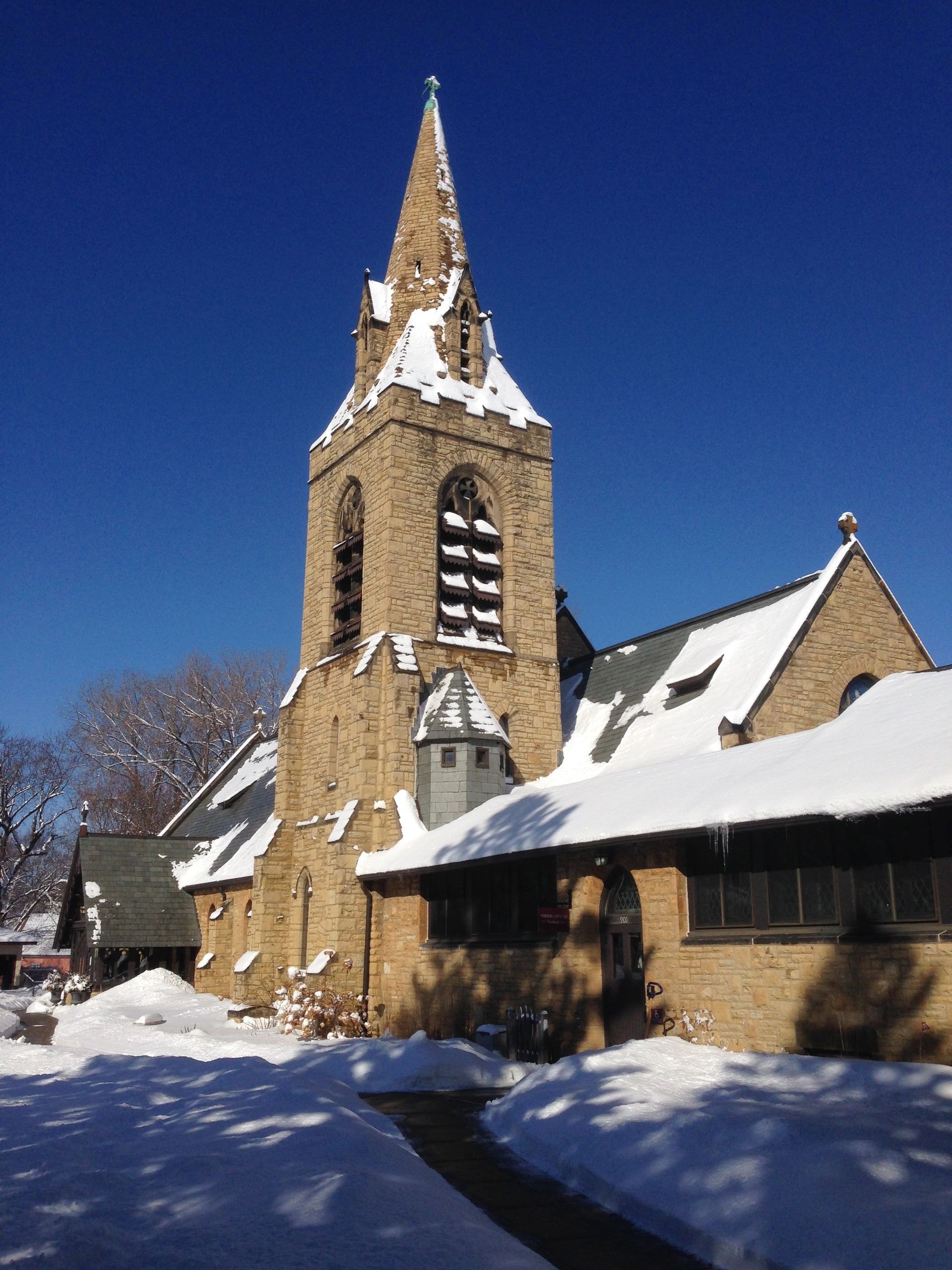 Stone church steeple in snow-covered winter landscape