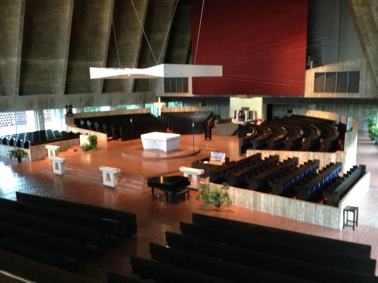 Modern church sanctuary interior with curved seating and red accent wall